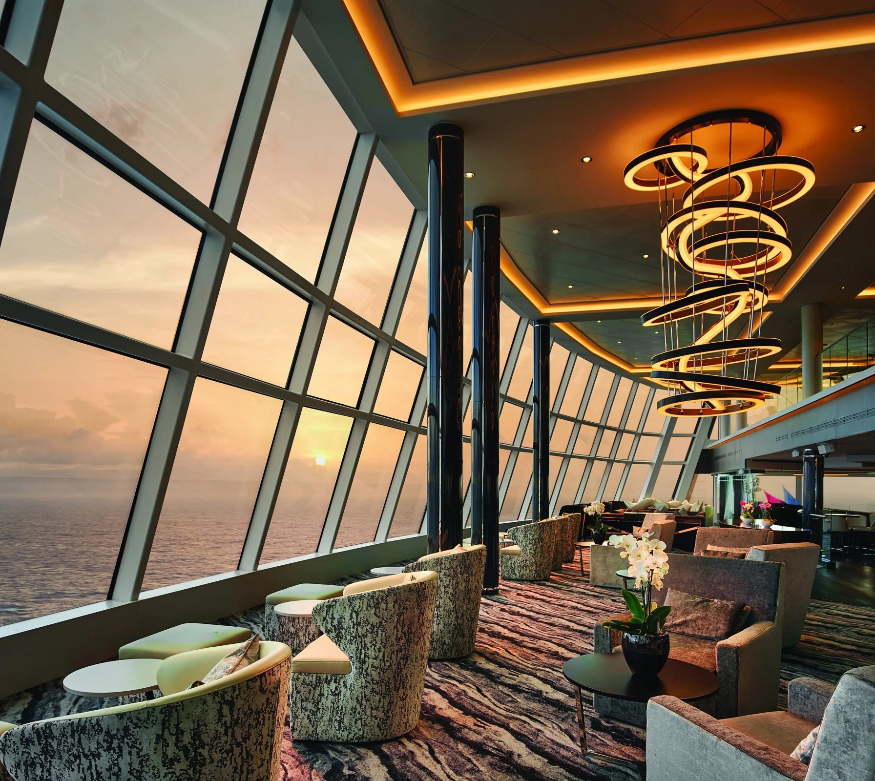 The Observation Lounge aboard Norwegian Bliss at sunset
