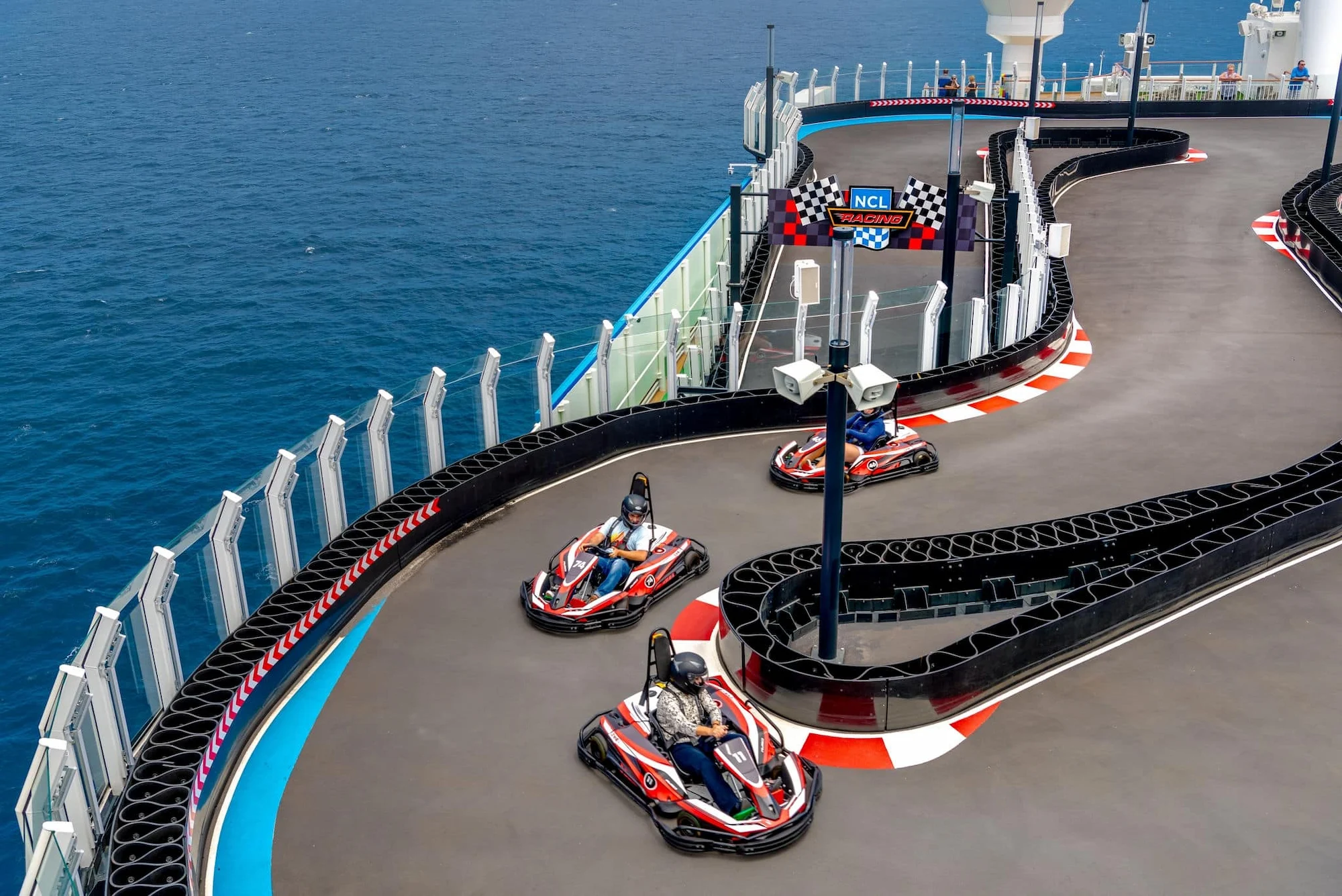 Guests racing go-karts on the Norwegian Bliss Speedway